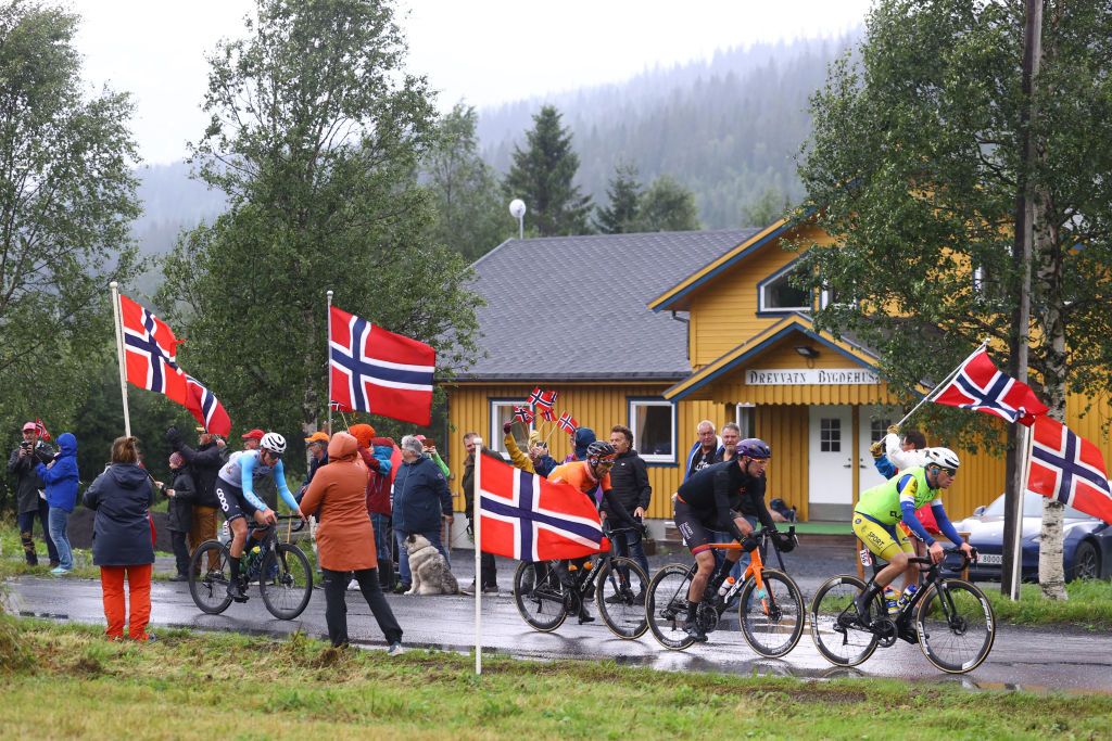 MO I RANA NORWAY AUGUST 11 Luis ngel Mat Mardones of Spain and Team Euskaltel Euskadi Erik Lunder of Norway and Team Coop Stephen Bassett of United States and Team Human Powered Health and Aaron Van Poucke of Belgium and Team Sport Vlaanderen Baloise compete in the breakaway passing through Molvikhammartunnelen Village while fans cheer during the 9th Arctic Race Of Norway 2022 Stage 1 a 1868km stage from Mo i Rana to Mo i Rana ArcticRace on August 11 2022 in Mo i Rana Norway Photo by Michael SteeleGetty Images