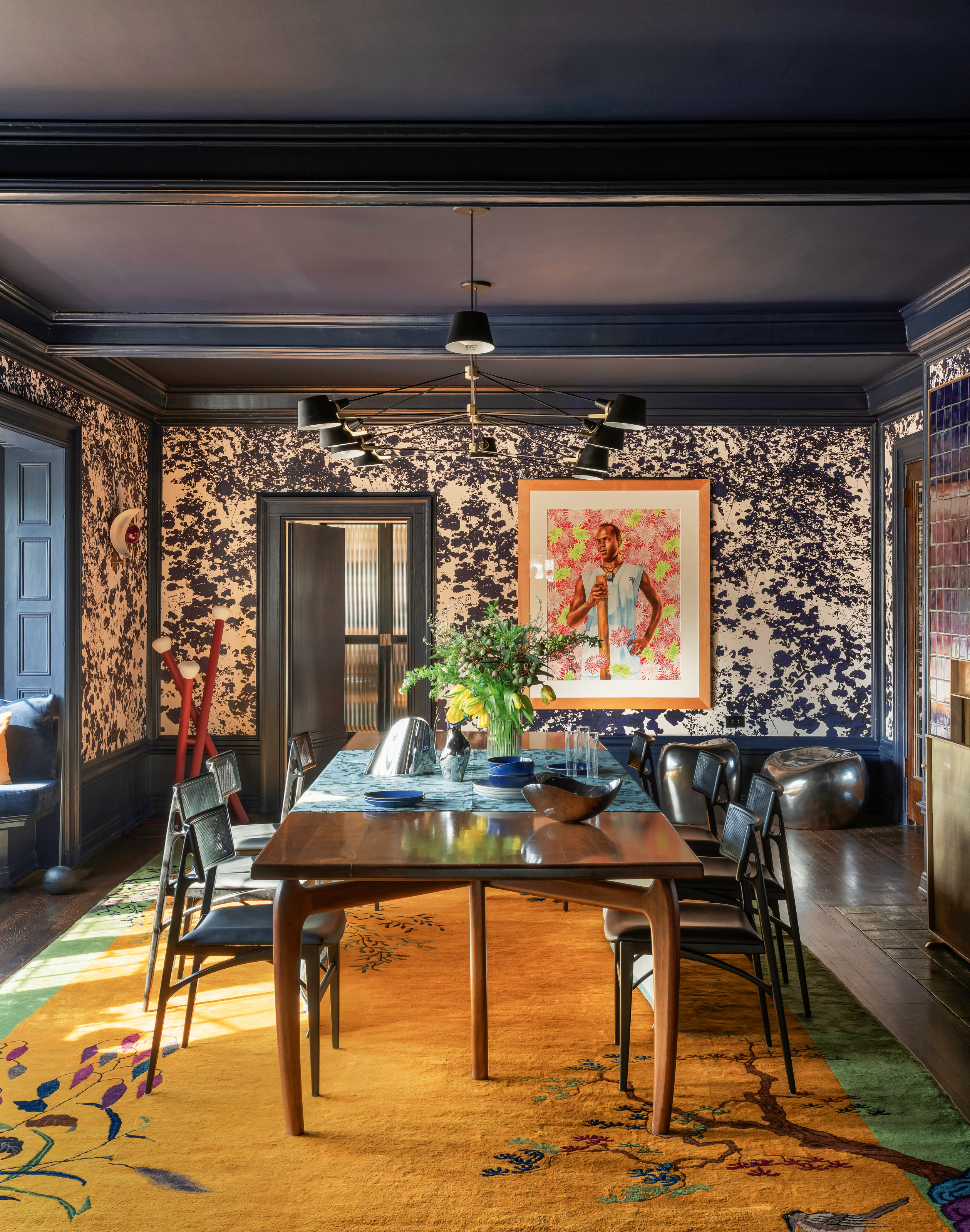 Dark blue dining room with patterned wallpaper and curved-leg table