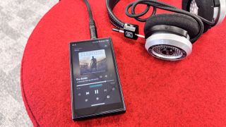 FiiO M21 portable music player plugged into a pair of Grado SR325x wired headphones