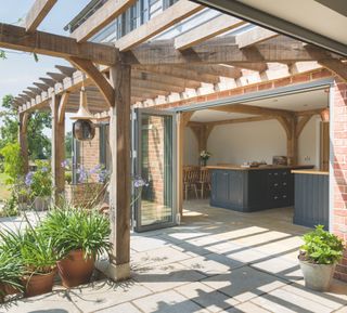 large kitchen with open bifold doors and shaded pergola