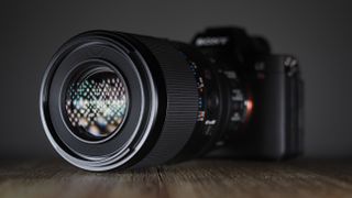 Sony FE 100mm f/2.8 Macro GM OSS on a wooden surface