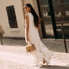 woman wearing a white dress and carrying a straw bag