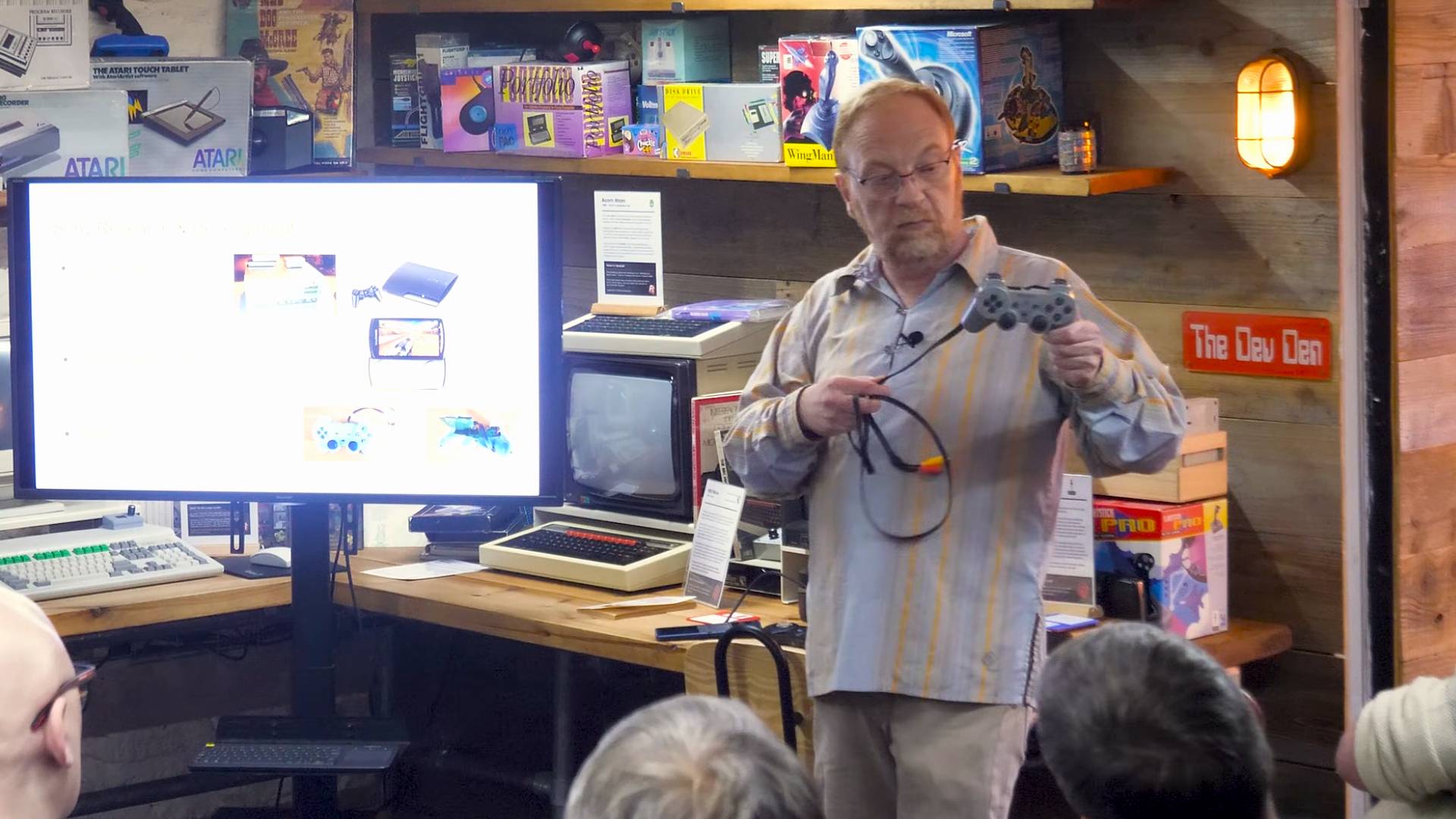 Brian 'Biscuit' Watson holding the PlayStation PUGA PS1 plug-and-play controller console during presentation.