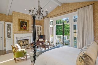 Yellow bedroom with fireplace and four poster bed in Hamptons style home