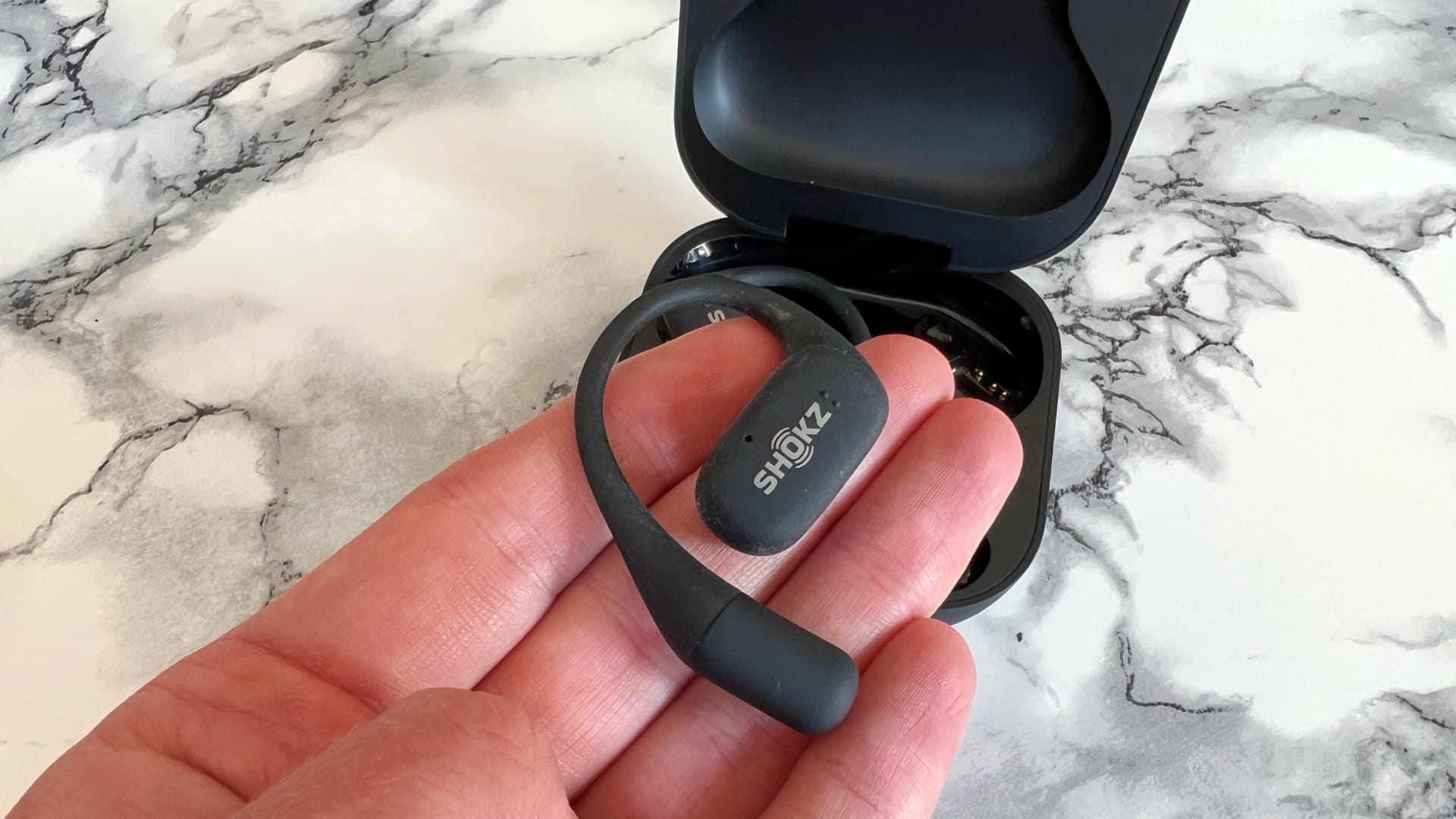 Shokz openfit mot marmorerat bord