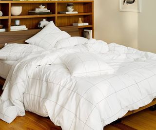 Brooklinen Down Duvet on a bed against a bookcase.