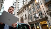 man using microsoft tablet in city