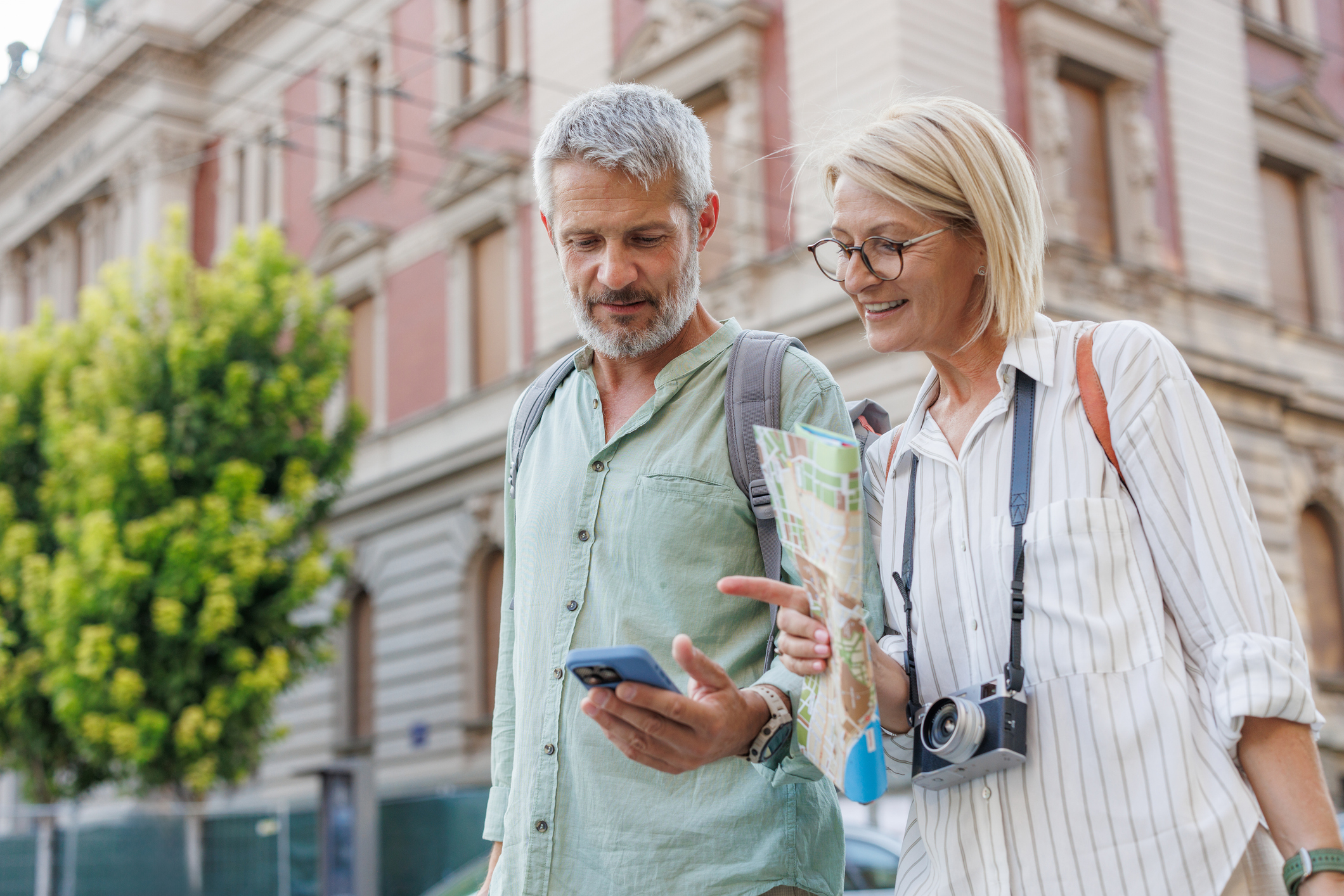 A couple traveling in a city looking at a map on their phone.