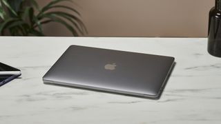 En MacBook Pro M2-modell på 13 tum ligger på ett skrivbord på ett kontor.
