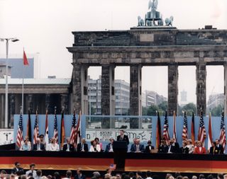 Photograph of President Reagan giving a speech at the Berlin Wall, Brandenburg Gate, Federal Republic of Germany.