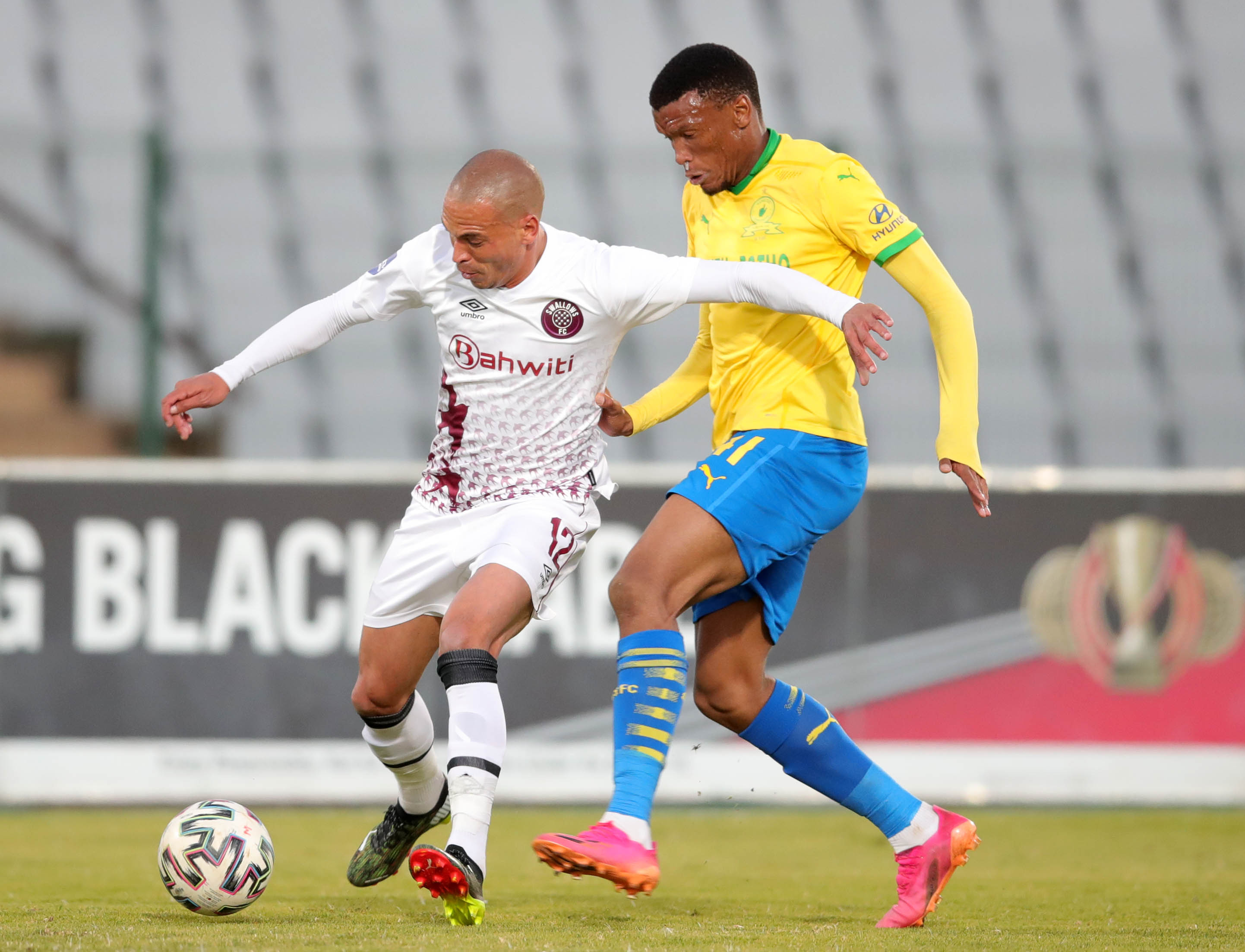 Ruzaigh Gamildien of Swallows challenged by Mothobi Mvala of Mamelodi Sundowns