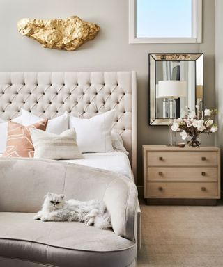 Cream bedroom with mirror and wood side table