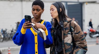 MILAN, ITALY - FEBRUARY 23: Models looking on phone outside Prada during the Milan Fashion Week Womenswear Fall/Winter 2023/2024 on February 23, 2023 in Milan, Italy. (Photo by Christian Vierig/Getty Images)