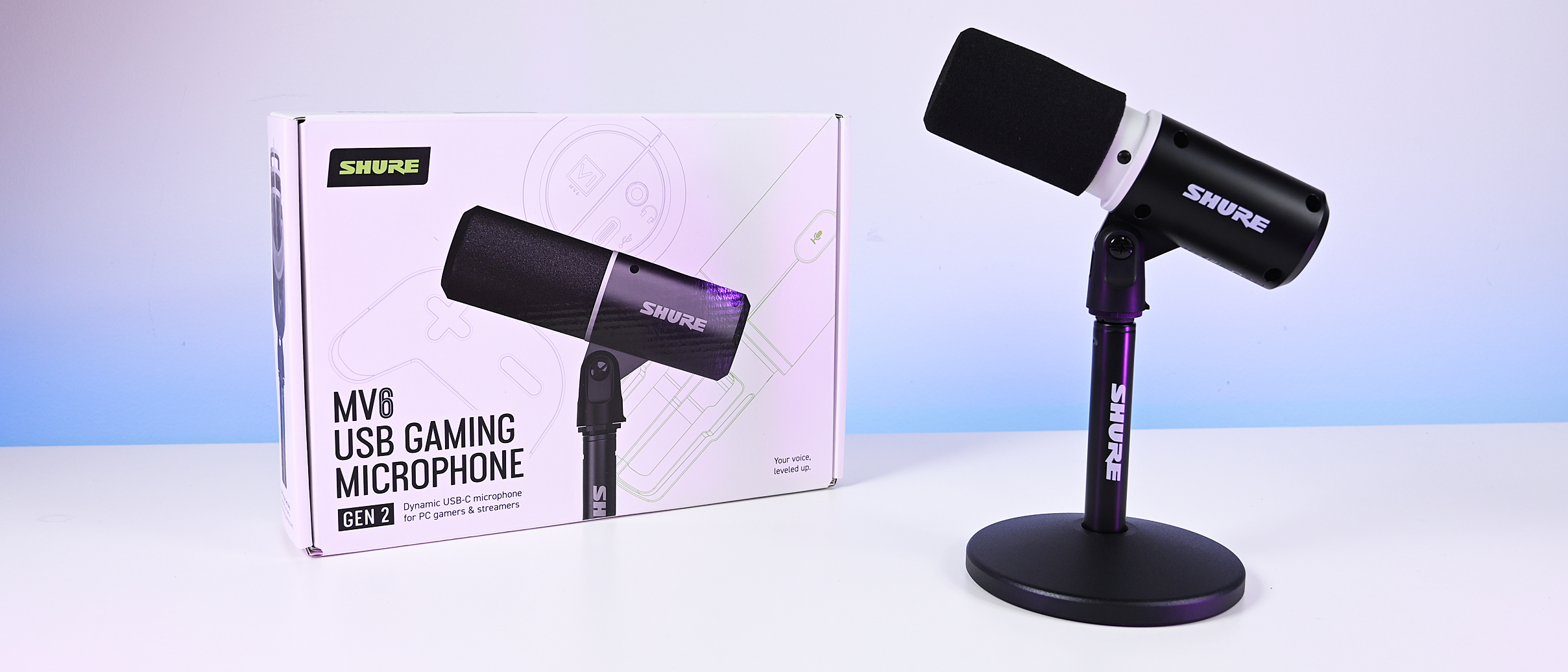 Black Shure MV6 USB Gaming Microphone Gen 2 on a desktop stand next to its white retail packaging box.