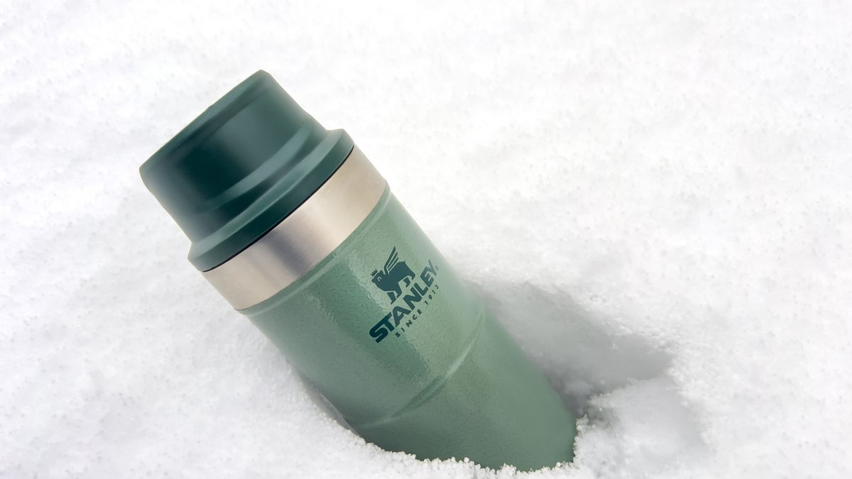 Stanley Trigger Action travel mug part-buried in snow