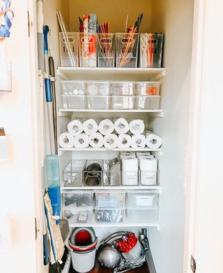 organized entryway closet with five white shelves packed with clear storage containers to organize the space