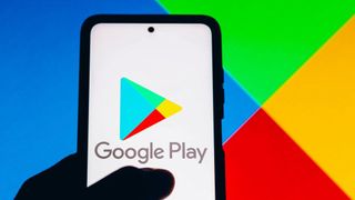 Google Play logo seen displayed on a smartphone with a thumb on top