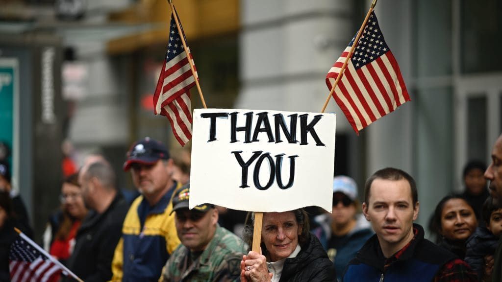 A woman holds a sign reading &amp;quot;Thank You&amp;quot; at a Veterans Day parade in New York City.