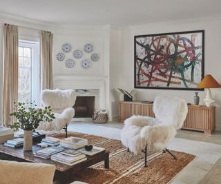 modern interior living area with white walls and wood sideboard and white fluffy chairs and abstract artwork