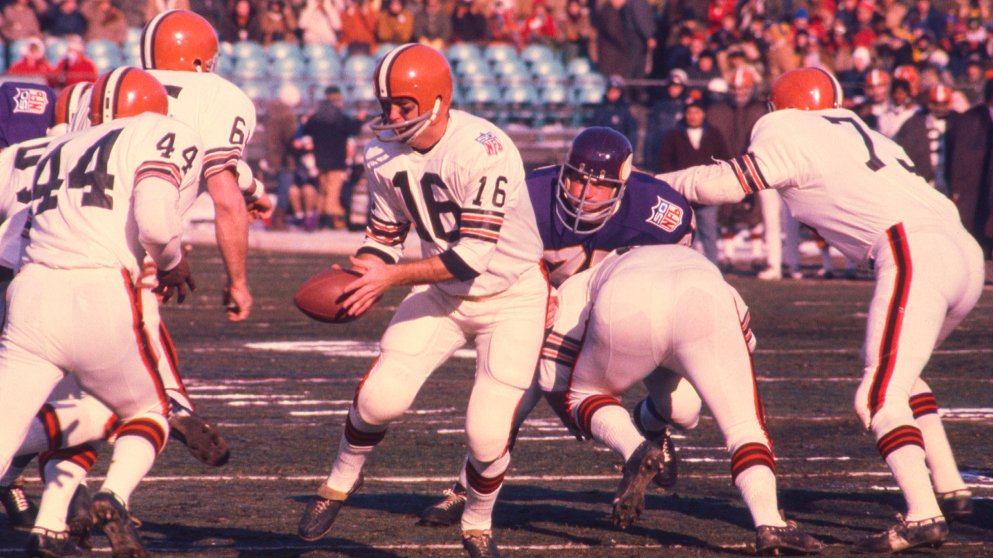 A sepia-toned photo of a series of American football players playing on a field