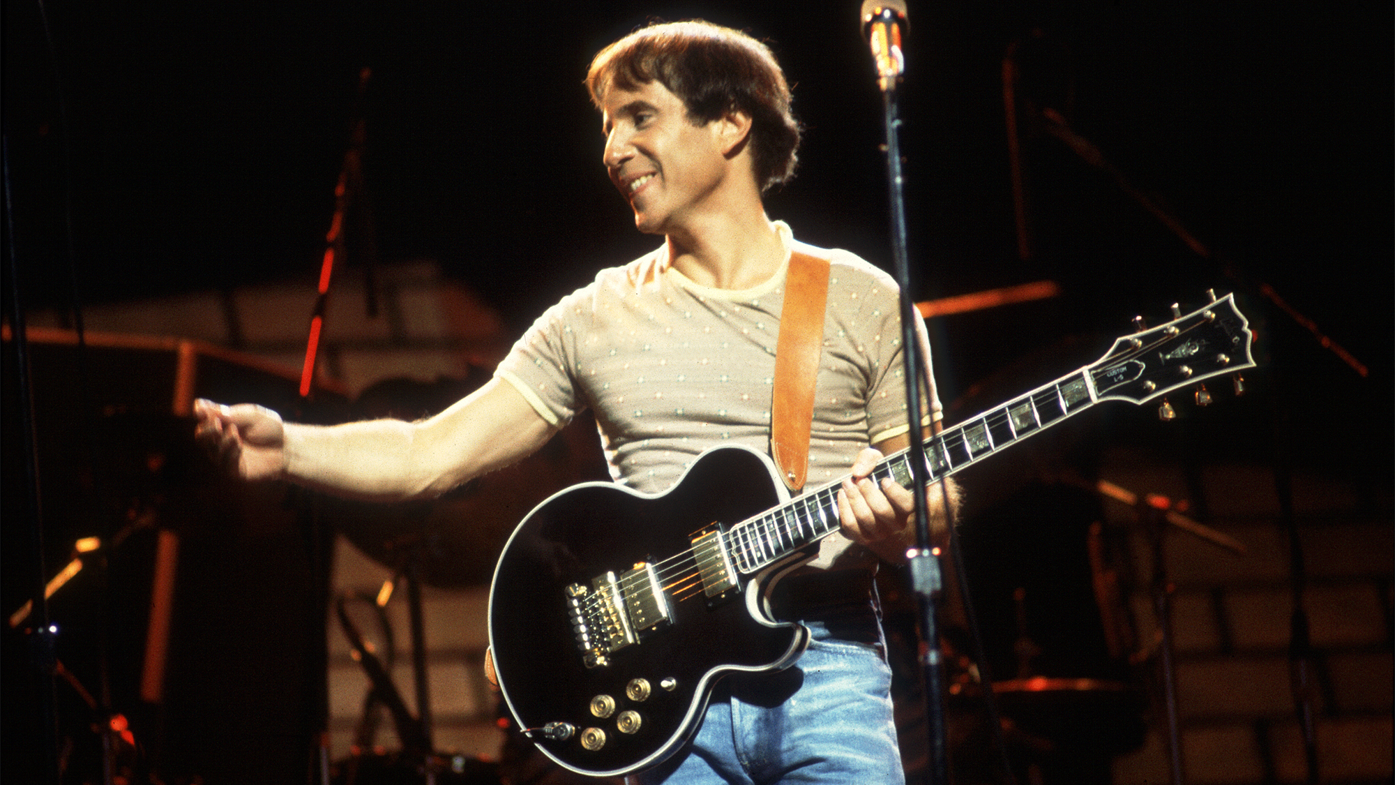 Paul Simon plays guitar as he performs onstage at the Auditorium Theater, Chicago, Illinois, September 25, 1980.
