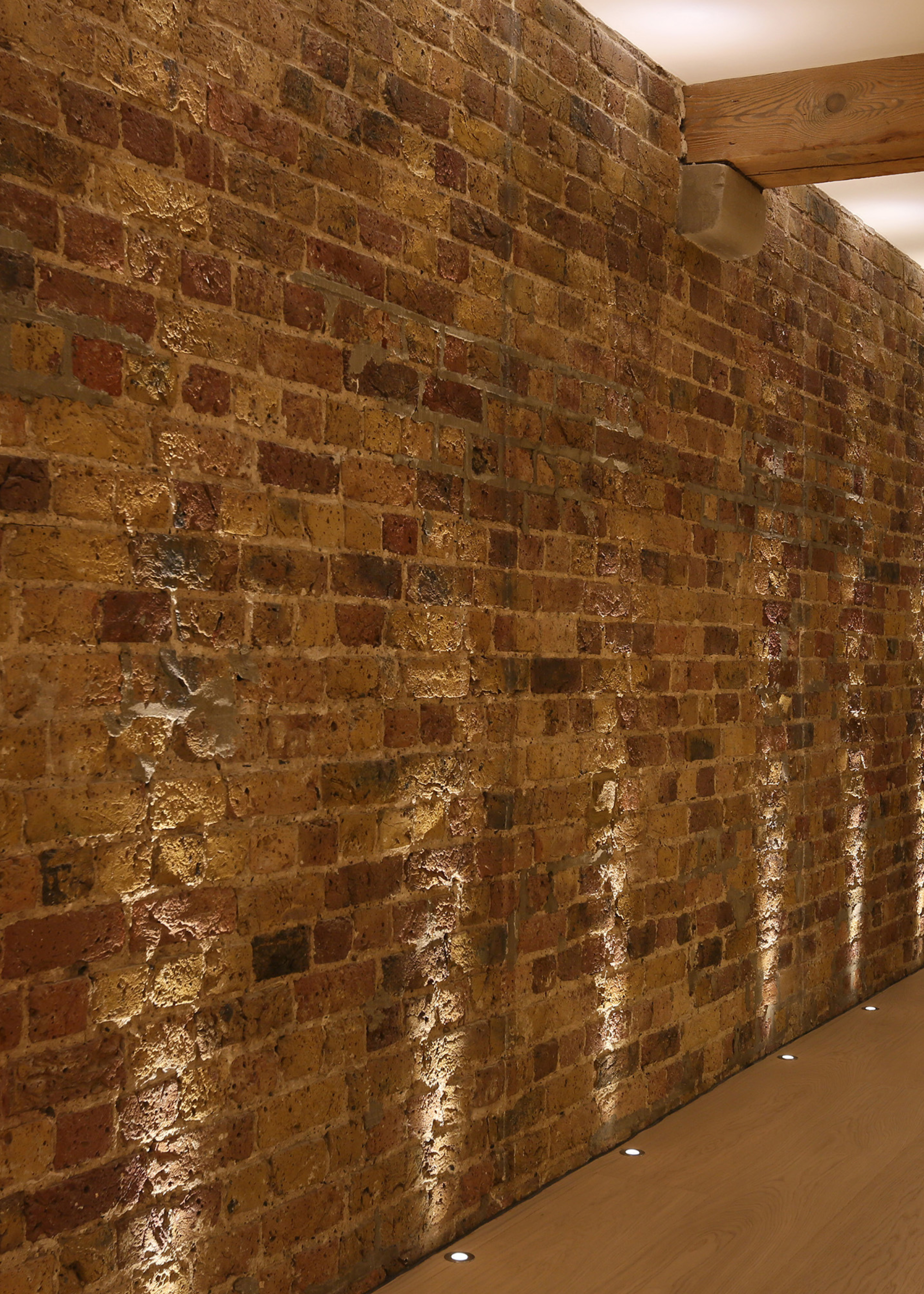 a brick wall illuminated by a few floor spotlights