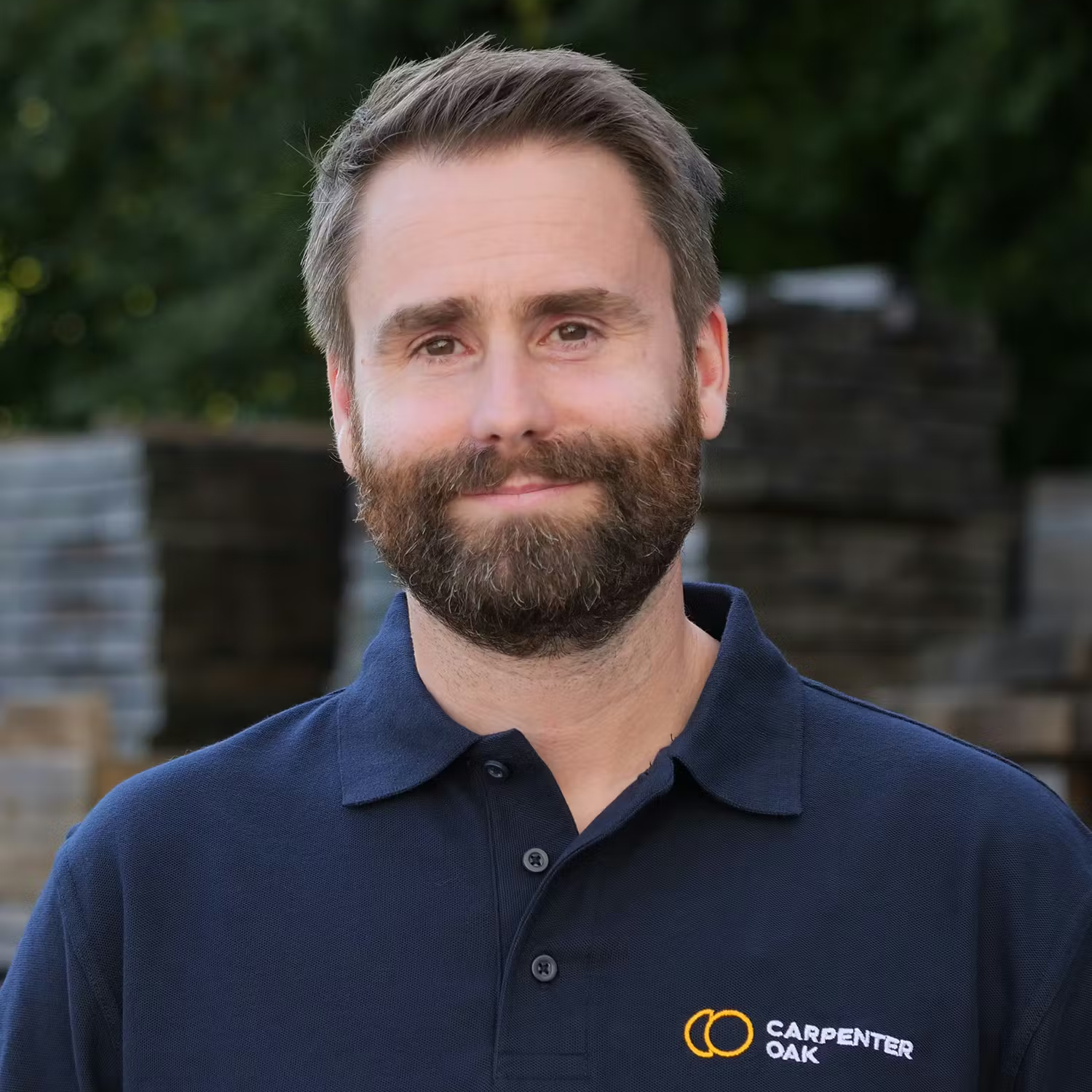 male with short hair and beard wearing navy polo short