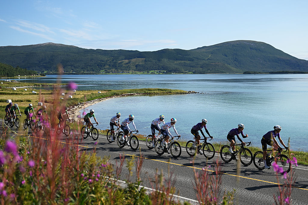 The peloton in front of a gorgeous landscape with water and mountains