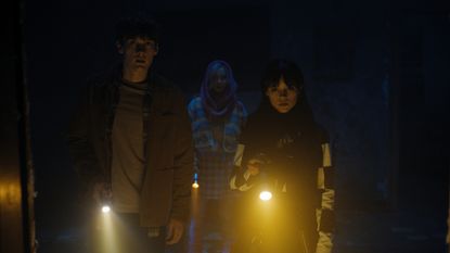 wednesday netflix series with wednesday tyler and enid in the dark holding flashlights