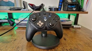 Thrustmaster eSwap X 2 review image of the controller on a stand in front of green lighting