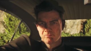 A young James Bond in 007 First Light furrowing his eyebrows. His face is dirty and he's in a car with a busted out window