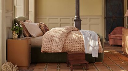 vintage-inspired panelled bedroom with a yellow checked rug, an upholstered bed with mis matched printed bed linens and a small wooden step stool