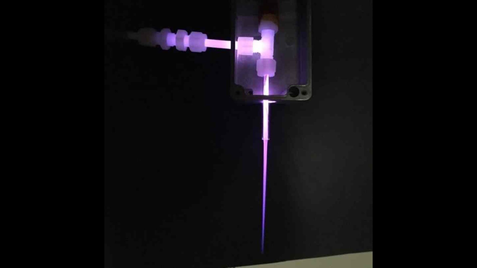 A purple thin line shoots out of an apparatus.