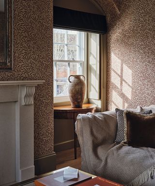 sitting room detail with patterned foliage wallpaper and side table