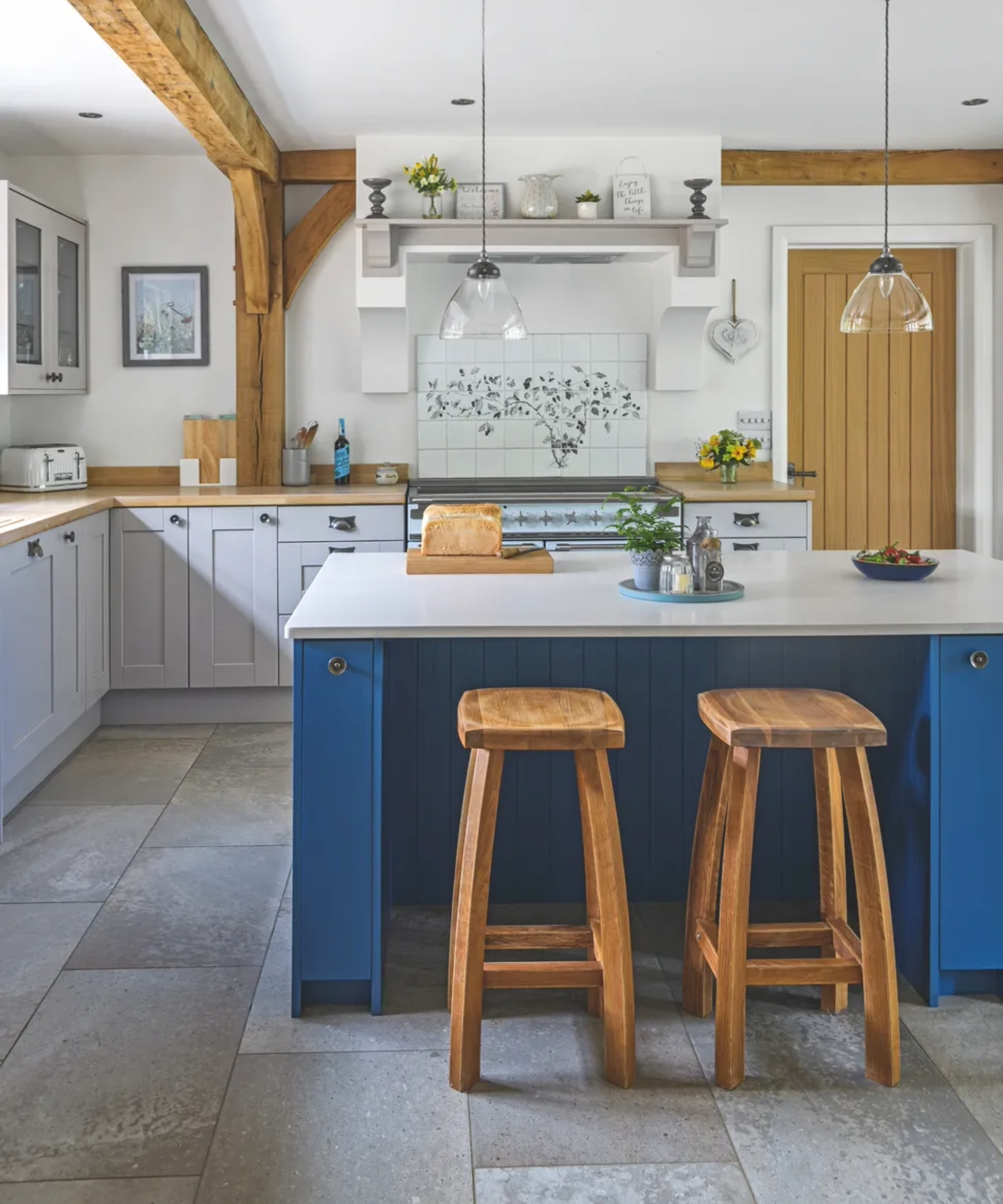country farmhouse kitchen with light and dark blue cabinets and grey flooring