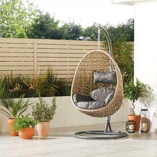 hanging egg chair with garden area and plants on pots