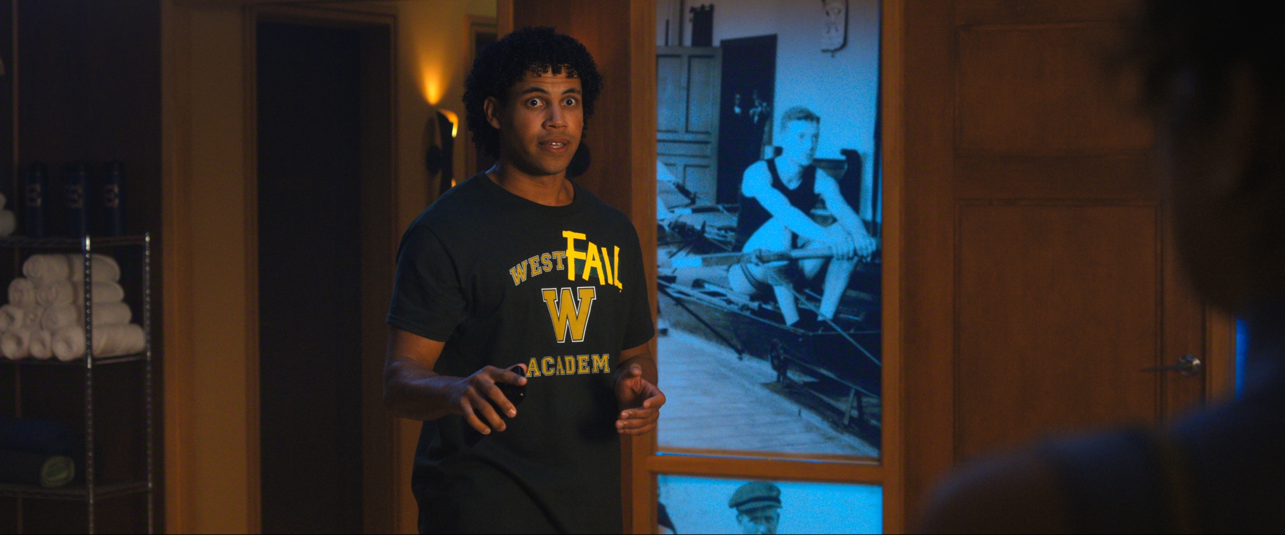 A male teenager (Jude Wilson as Baloo Garner) stands in a crew-team clubhouse, in Netflix's 'Crew Girl.'
