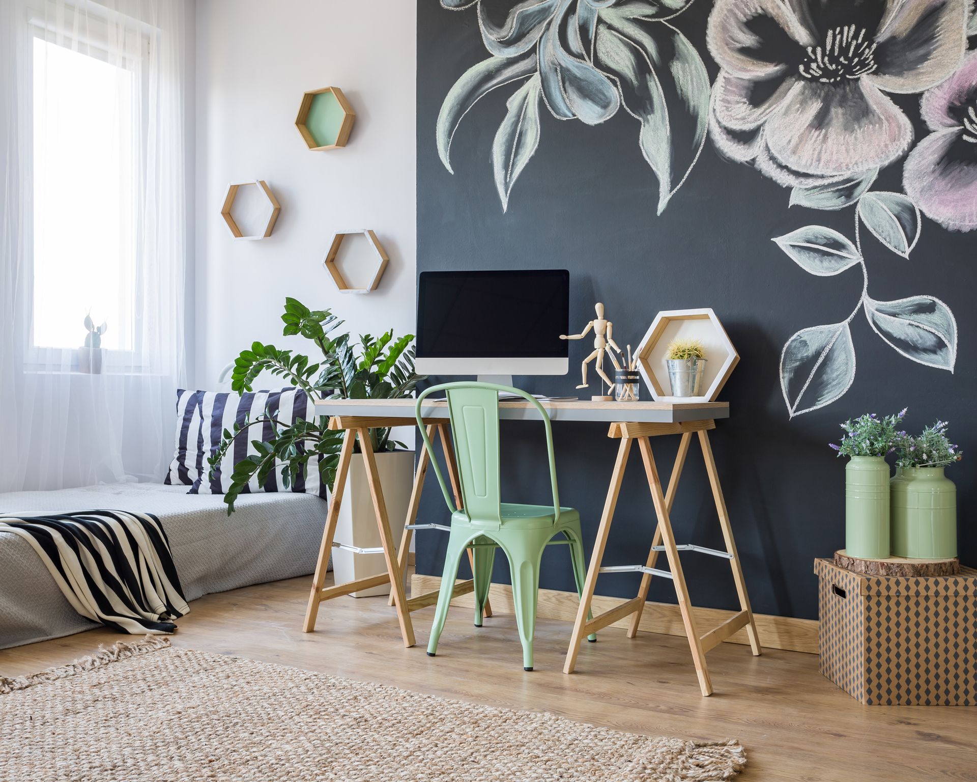 A bright studio apartment with a stencilled wall