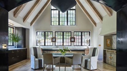 Black arch leading to kitchen with high vaulted ceiling, black cabinets and range cooker 