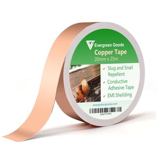 roll of copper tape sitting on its edge with one end falling down on a white background