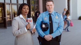 Seth Rogen is interviewed by the news in his mall cop uniform.