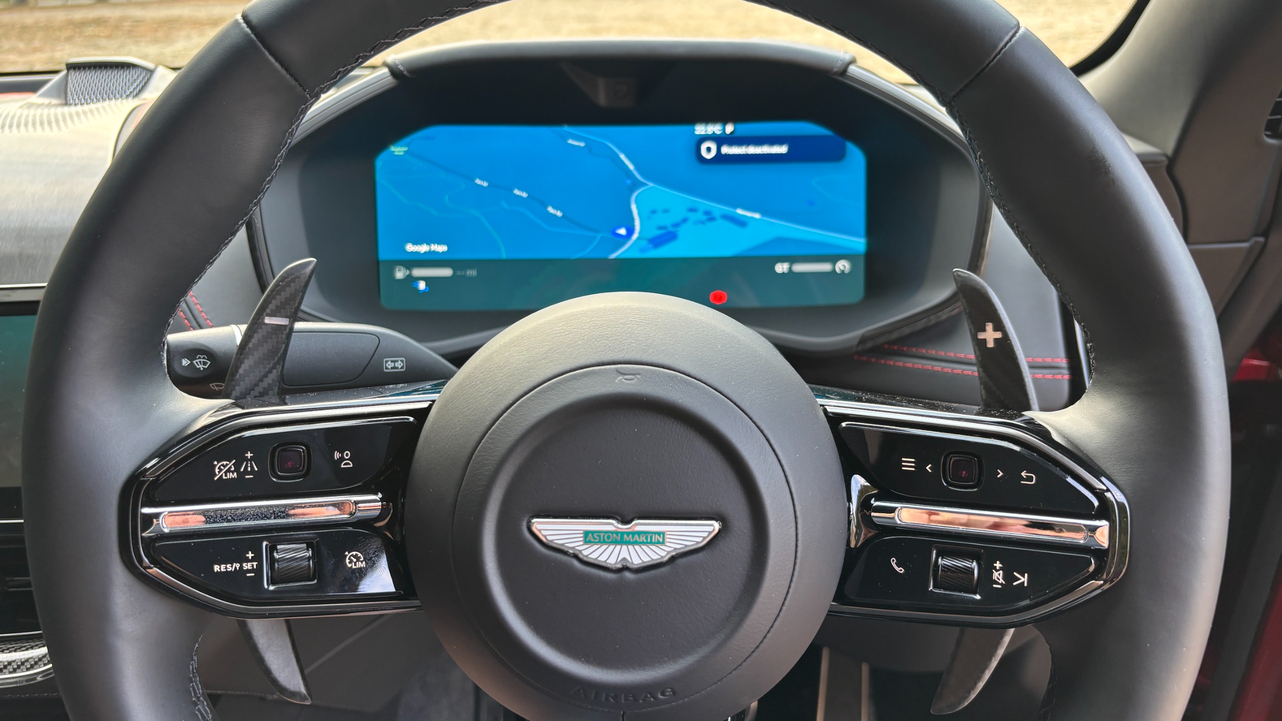 The view of an Aston Martin DBX S cockpit from behind the steering wheel
