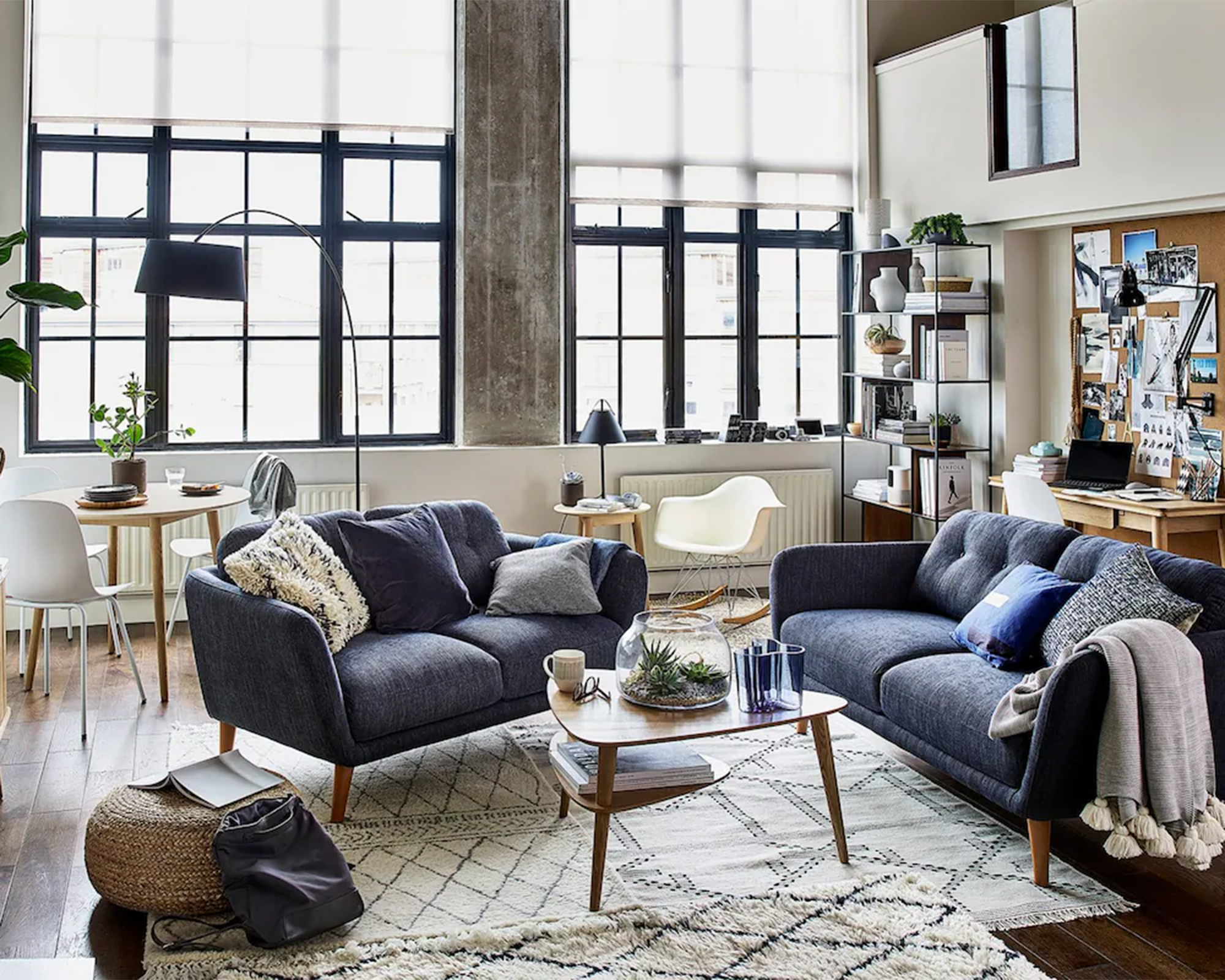 A blue open plan living room with dining area, working space and a centrally located living space