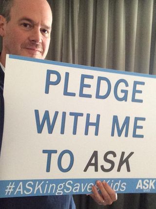 ESPN's Rich Eisen holds a sign supporting the ASK Campaign.