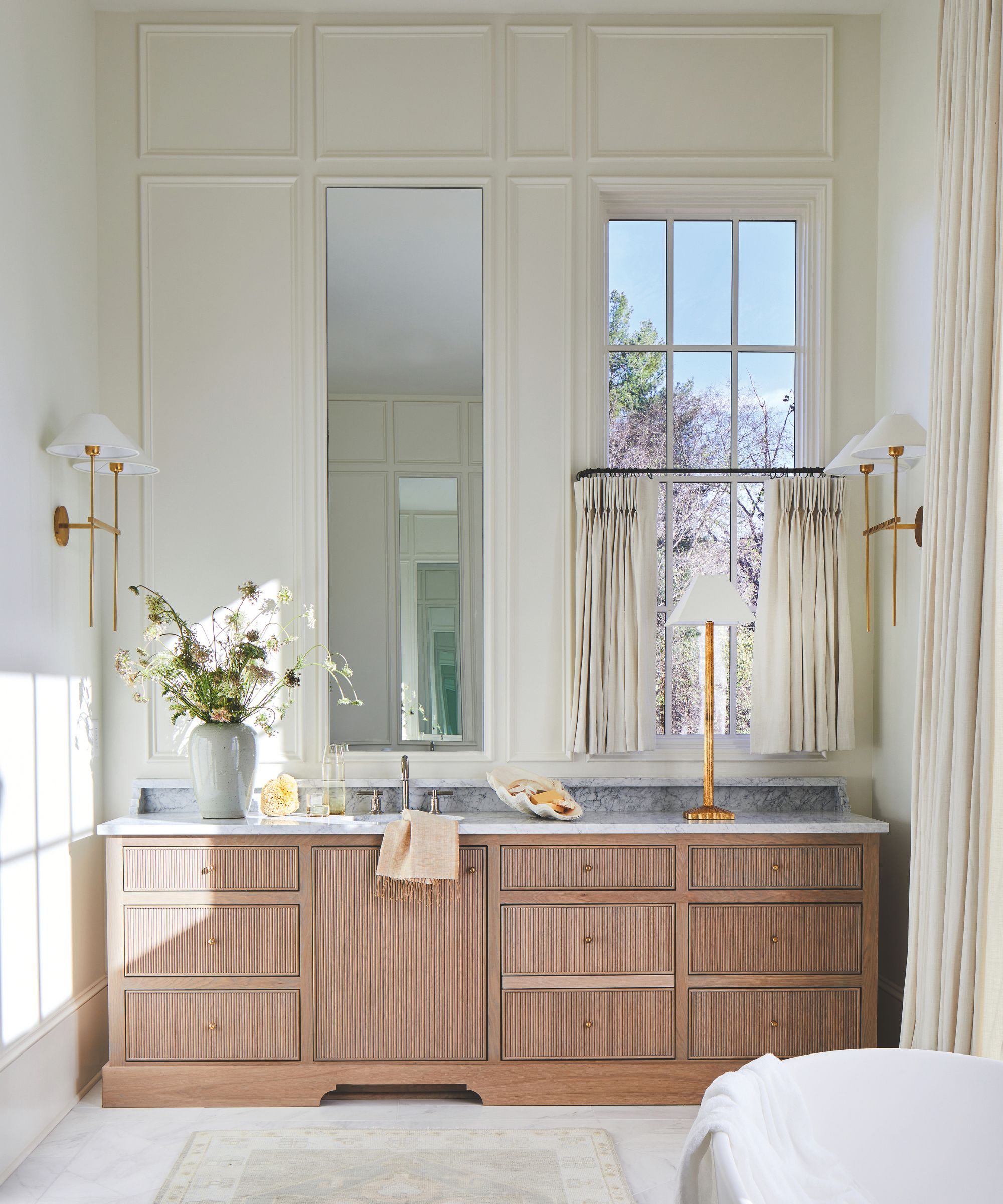 Neutral bathroom with wall panelling and a wooden vanity in a fluted wooden design