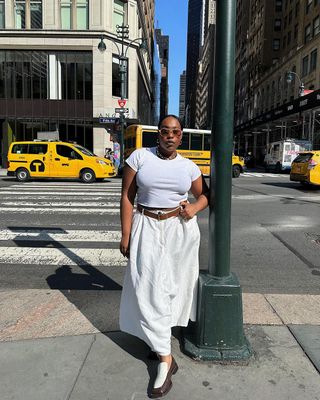 @aniyahmorinia wearing white t-shirt, white maxi skirt, and loafers on the streets of NYC