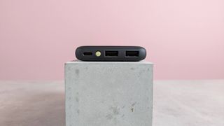 Iniu B41 power bank on plinth on desk with pink background