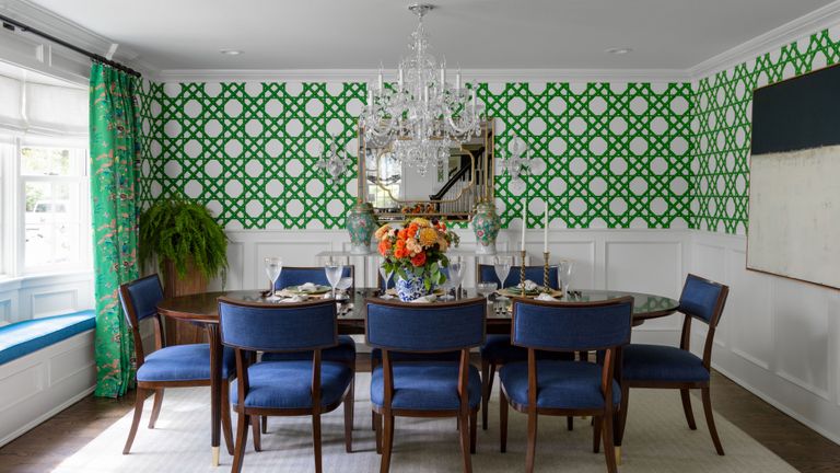 dining room with bright green trellis geometric wallpaper and blue chairs with green patterned curtains and window seats
