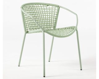 A sage green weather-resistant resin rattan outdoor dining chair