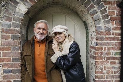 Happy couple embracing affectionately outdoors by a brick archway in the U.K.